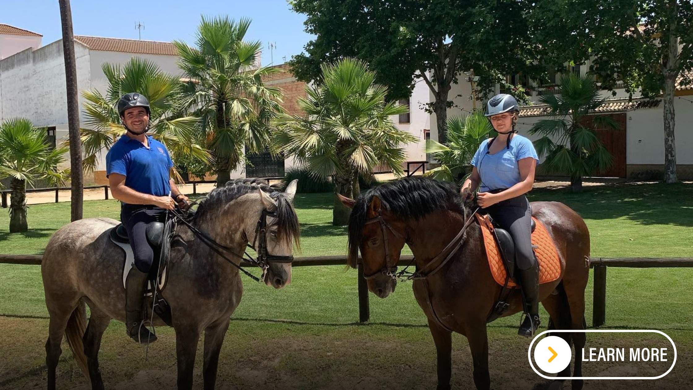 Two visiting riders smiling onboard Spanish horses.